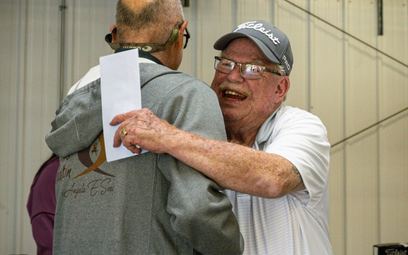 Two supporters embracing at the AES Cancer Foundation golf tournament.